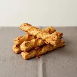 Csavart sajtos rudak egymásra rakva.